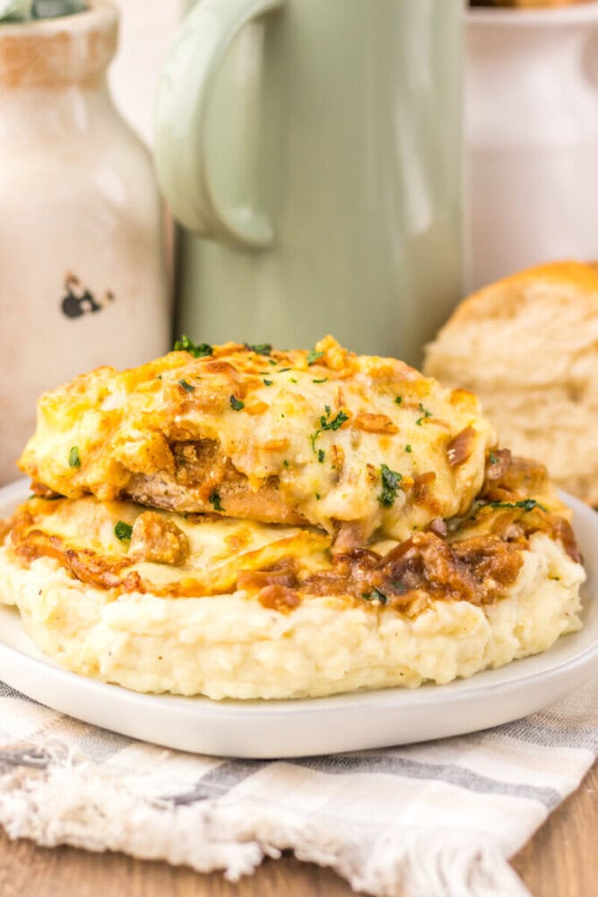 French onion chicken bake with melted cheese and caramelized onions on mashed potatoes garnished with parsley