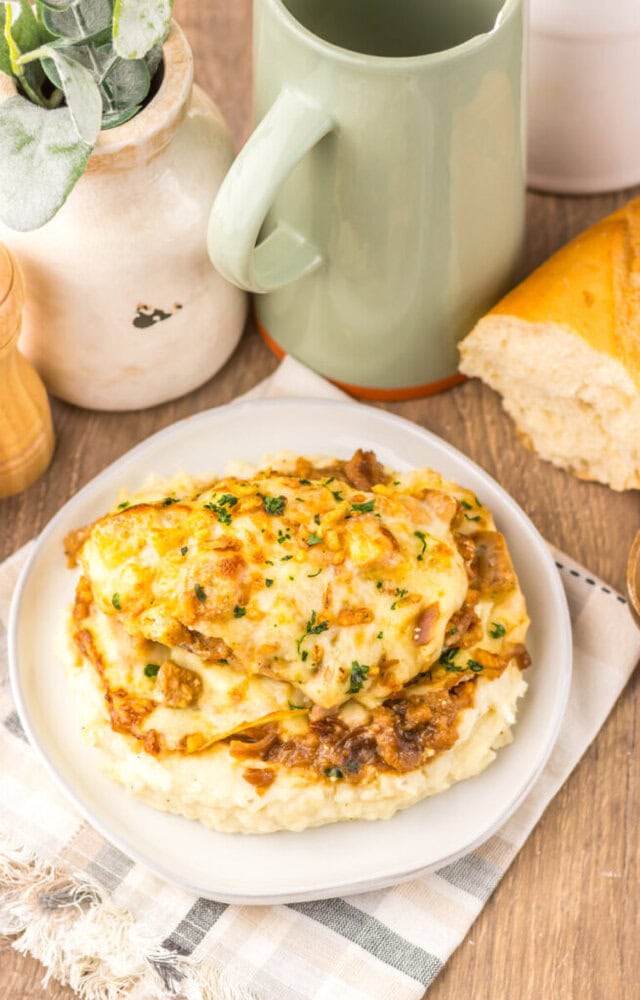 French Onion Chicken Bake with melted cheese and caramelized onions served over mashed potatoes