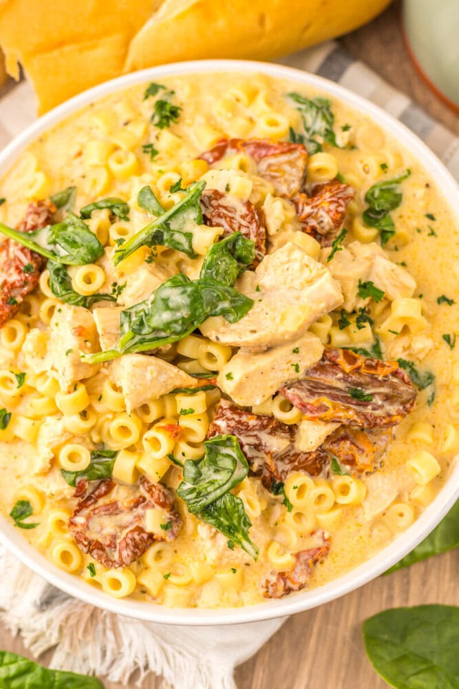 Slow cooker marry me chicken soup with pasta, chicken, sun-dried tomatoes and fresh basil in cream sauce