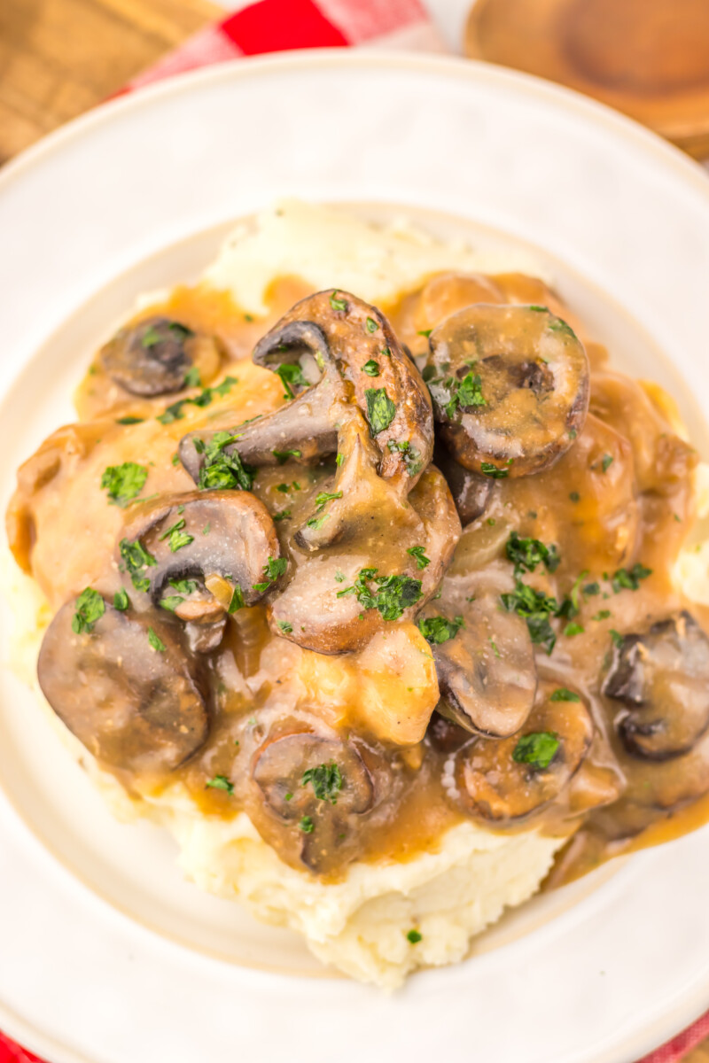 Slow Cooker Salisbury Chicken with mushrooms and gravy over mashed potatoes garnished with parsley