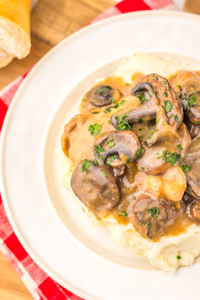Slow Cooker Salisbury Chicken with mushroom gravy and mashed potatoes plated in white bowl