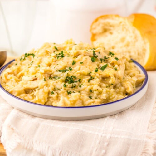 Creamy chicken and rice risotto garnished with parsley in a plated bowl, ready to serve