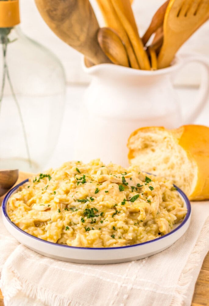 Slow cooker butter chicken and rice plated and garnished with parsley, served with fresh bread