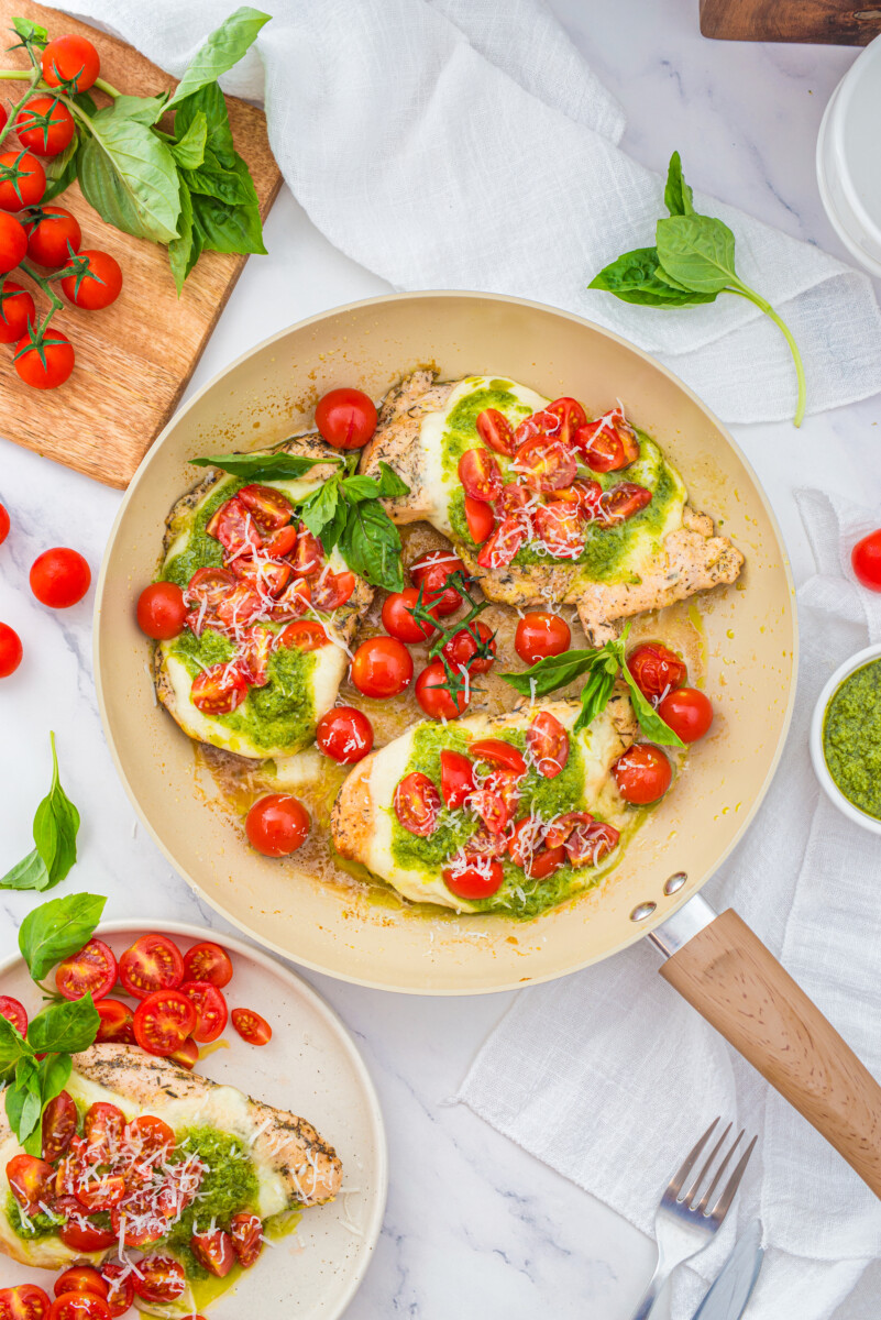 Chicken Margherita with fresh mozzarella, basil, and tomato in a pan, styled food photography overhead view