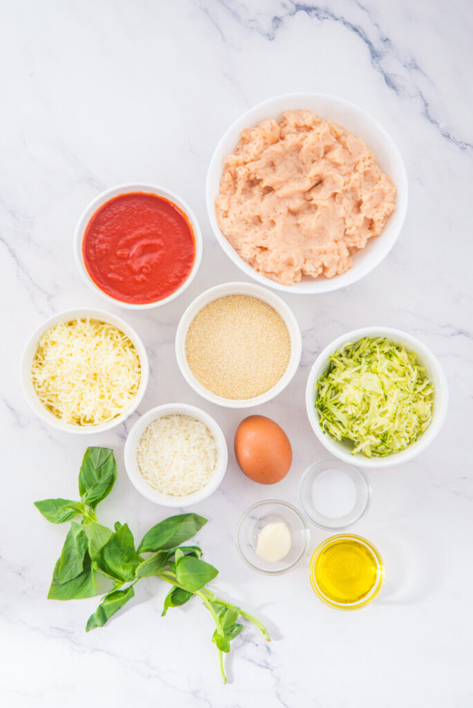 Chicken Parmesan Meatballs ingredients prepped in bowls including ground chicken, breadcrumbs, parmesan, mozzarella, tomato sauce, and fresh basil