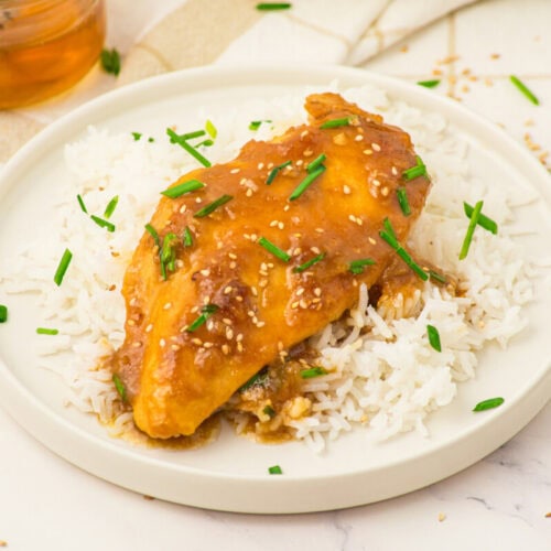 Honey butter chicken with sesame seeds and green onions served over white rice