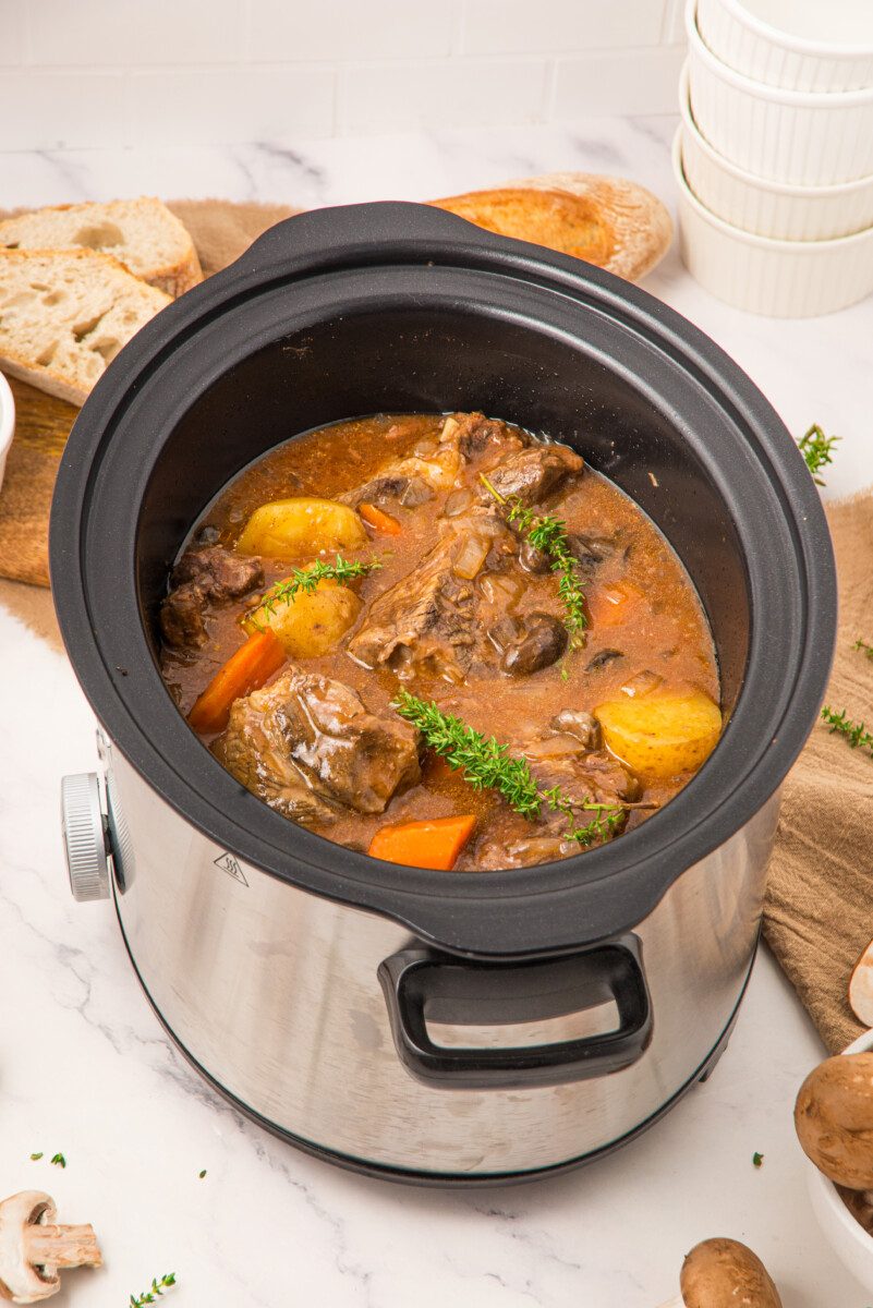 Slow cooker beef pot roast with potatoes and carrots garnished with parsley, ready to serve