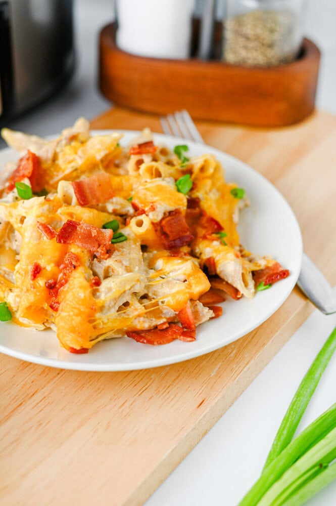Crockpot Crack Chicken Pasta with bacon, cheese, and green onions on white plate