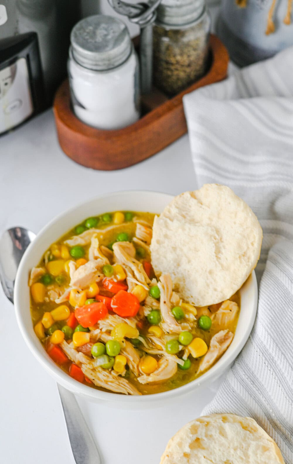 Crock pot chicken and biscuits - creamy chicken stew with corn, peas, and red peppers served with buttered biscuits