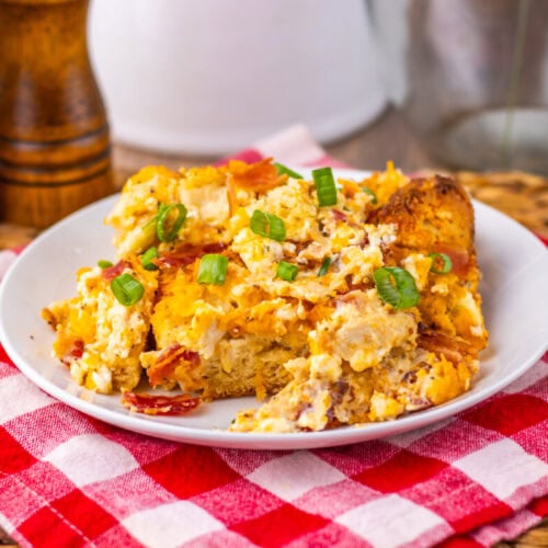 Chicken Bacon Ranch Bubble Up Bake casserole plated and garnished with green onions on a red checkered napkin
