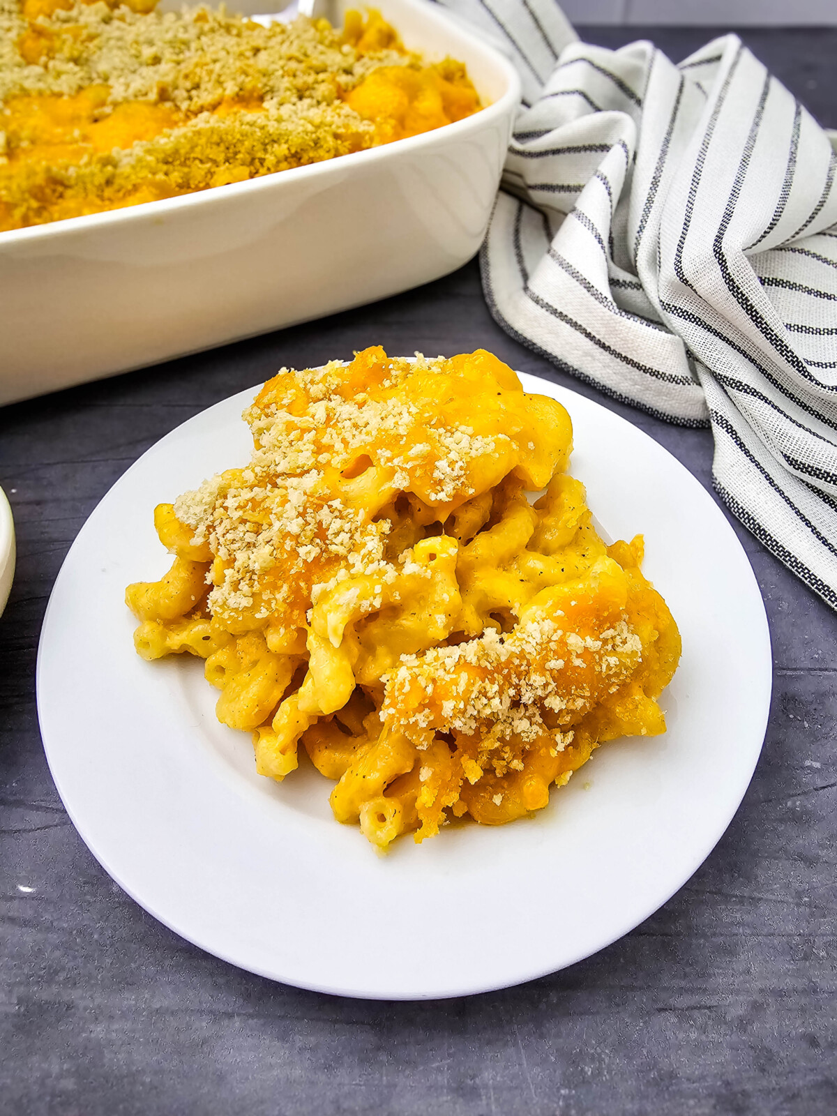 Crab mac and cheese plated on white dish with crispy breadcrumb topping