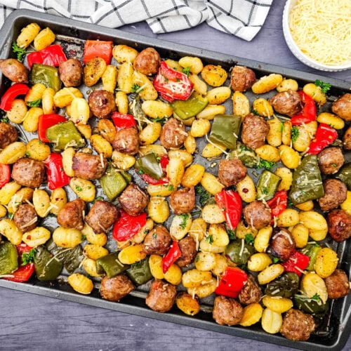 Sheet pan sausage and gnocchi with roasted vegetables and fresh parsley garnish