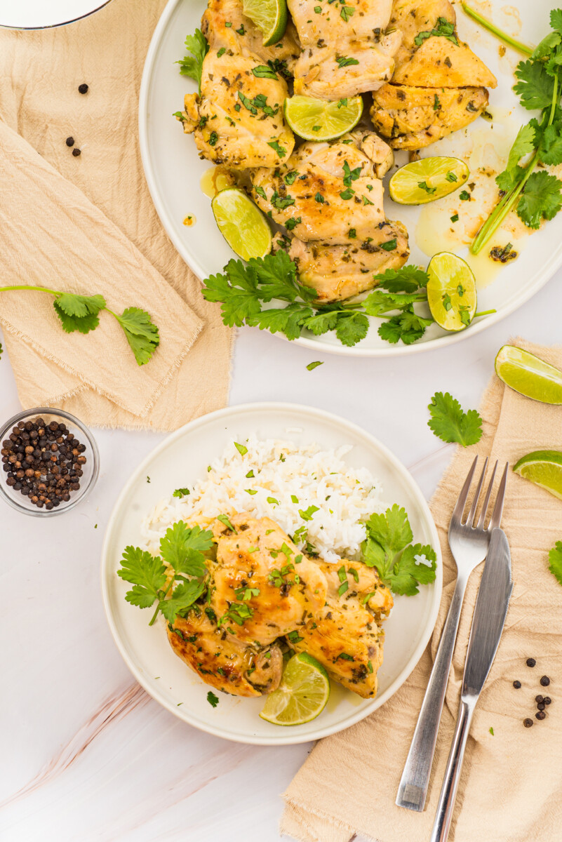 Cilantro lime chicken served with white rice, garnished with fresh cilantro and lime slices on white plates