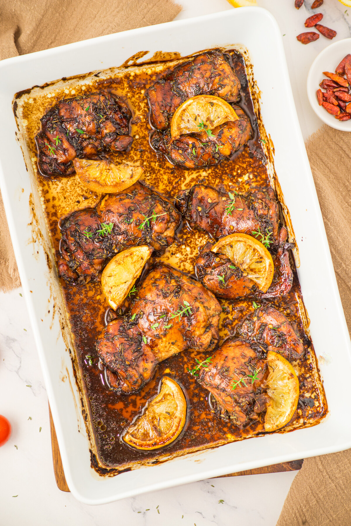 Honey balsamic chicken thighs with lemon slices in baking dish, ready to serve