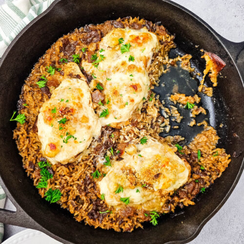 Skillet French onion chicken and rice with melted cheese in cast iron pan
