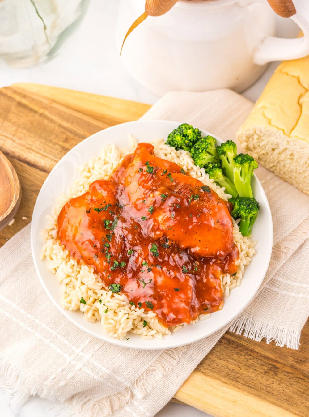 Slow cooker Catalina chicken over rice with broccoli on white plate