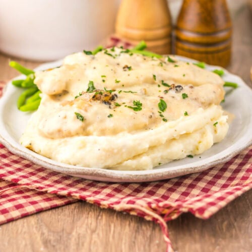 Slow cooker chicken au poivre with mashed potatoes and black pepper garnish on white plate