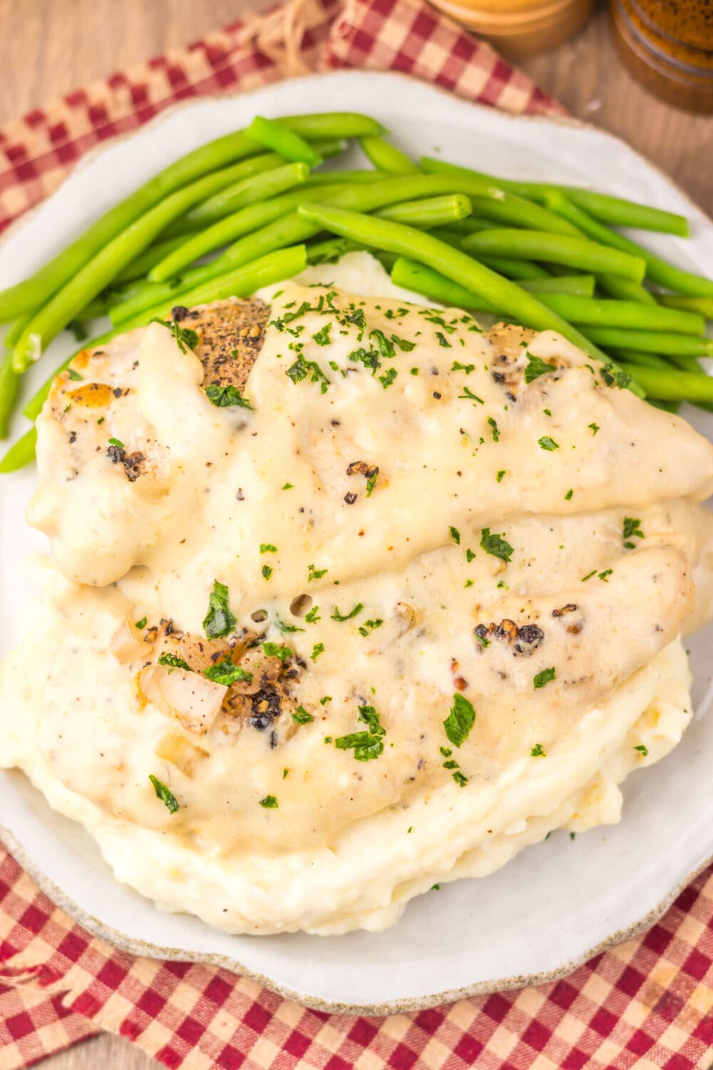 Slow cooker chicken au poivre with peppercorn crust served over mashed potatoes and green beans