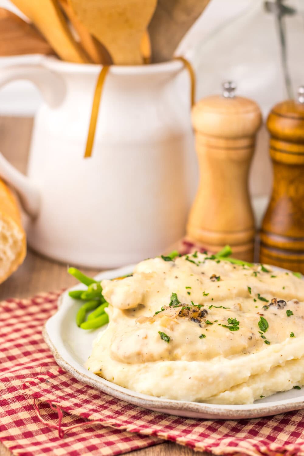 Slow cooker chicken au poivre plated with creamy sauce and fresh herbs garnish