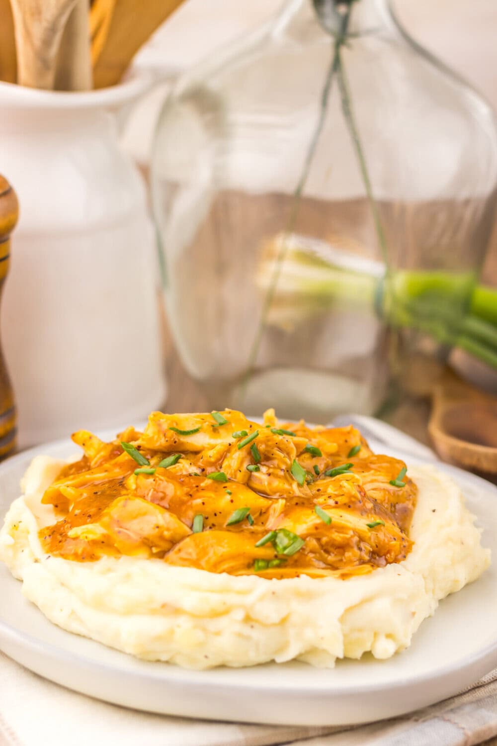 Slow cooker teriyaki chicken with caramelized onions served over mashed potatoes with green onion garnish