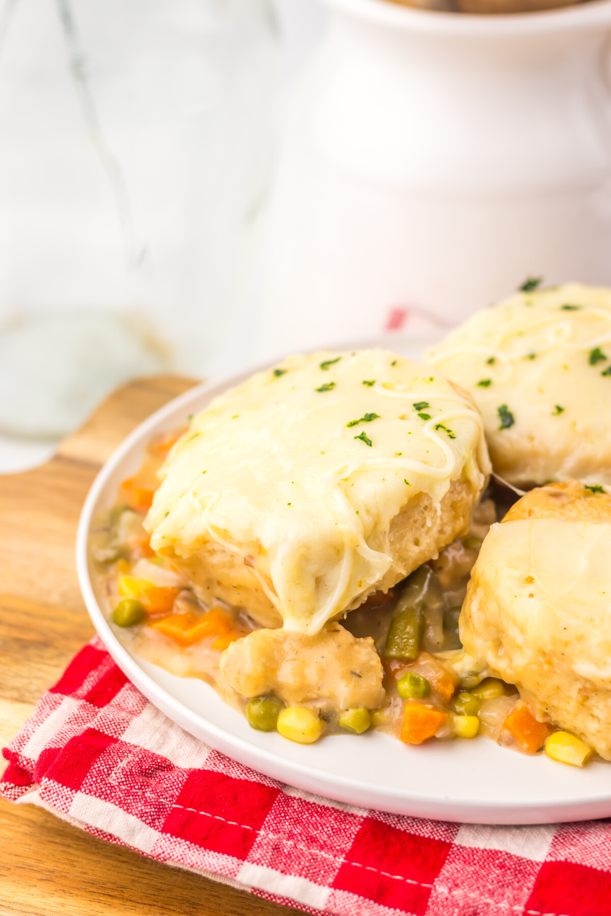 Slow cooker French onion chicken pot pie with golden pastry crust and vegetables on white plate