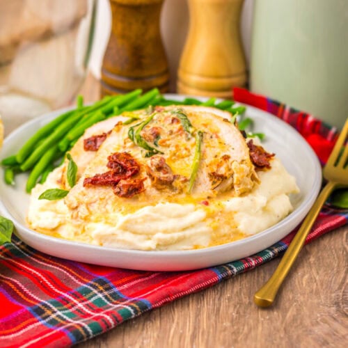 Slow cooker marry me turkey breast with cream sauce and bacon garnish on white plate with green beans and bread