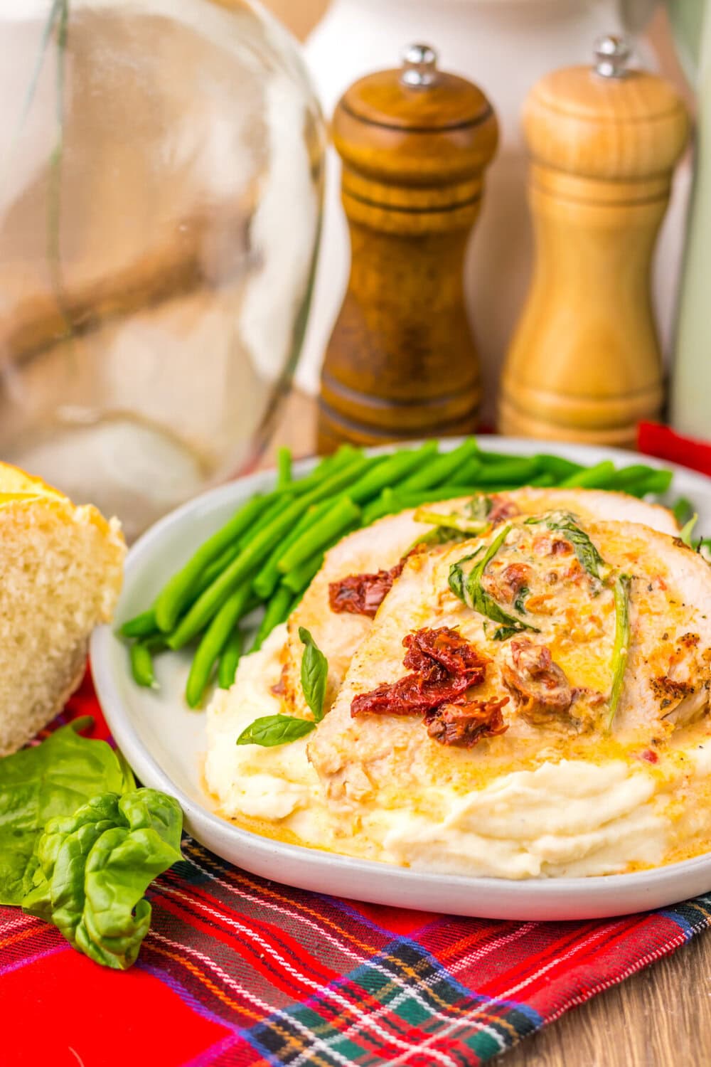 Slow cooker marry me turkey breast plated with green beans and bacon garnish