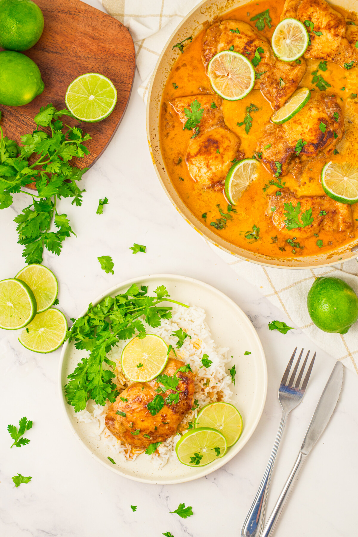 Coconut lime chicken served over rice with cilantro and lime garnish on white plate